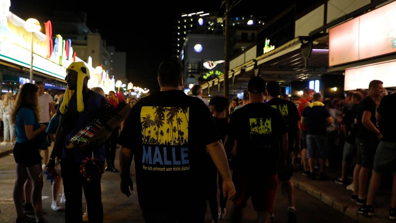Männer, die ein T-Shirt mit der Aufschrift „Malle“ tragen, gehen durch die Schinkenstraße im sogenannten Ballermann-Viertel auf Mallorca.