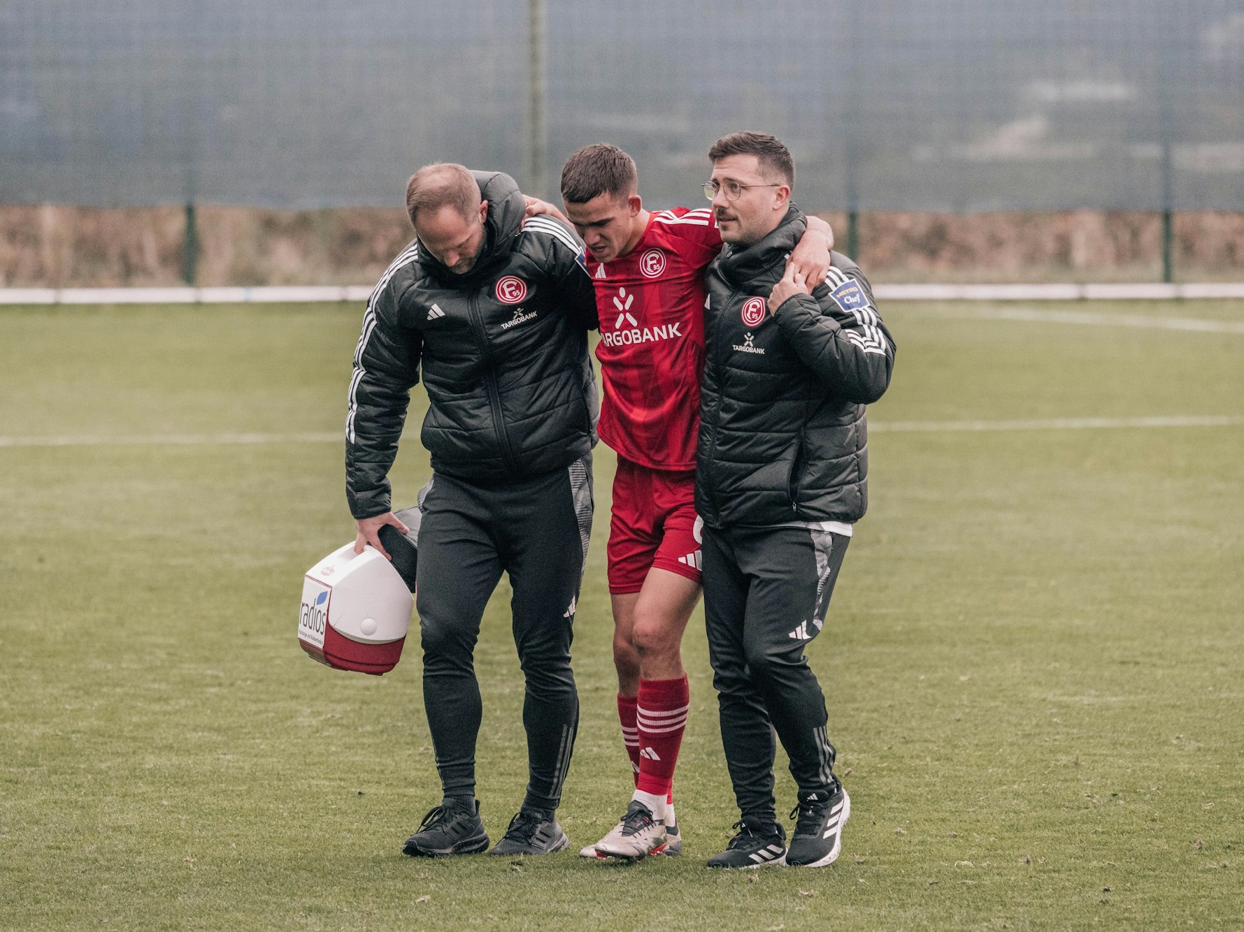 Der verletzte Giovanni Haag wird gestützt vom Platz gebracht.