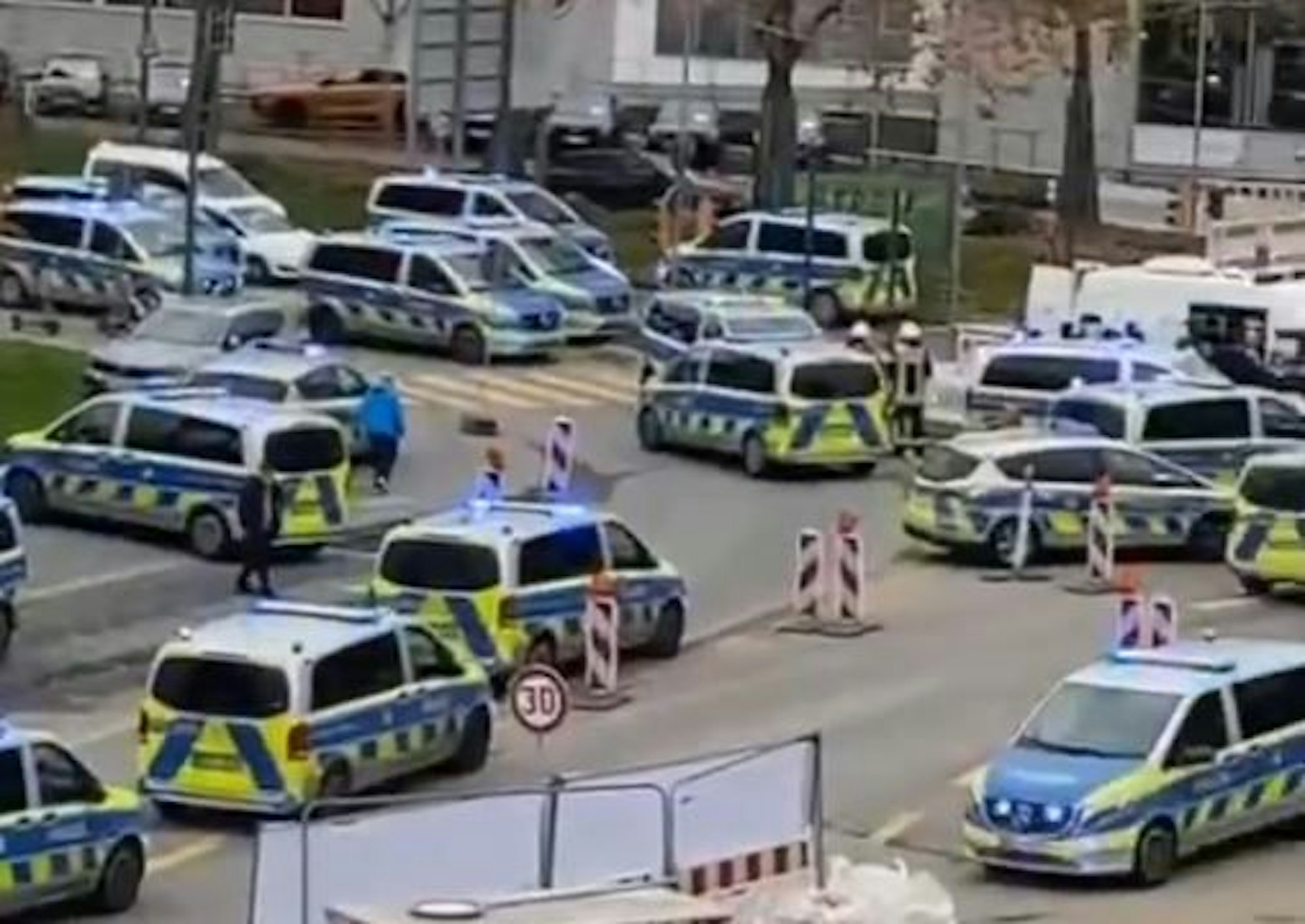 Auf und an einer Straße stehen zahlreiche Polizeifahrzeuge.