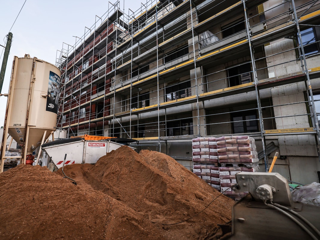 Ein Gerüst steht am Rohbau eines Wohnhauses.