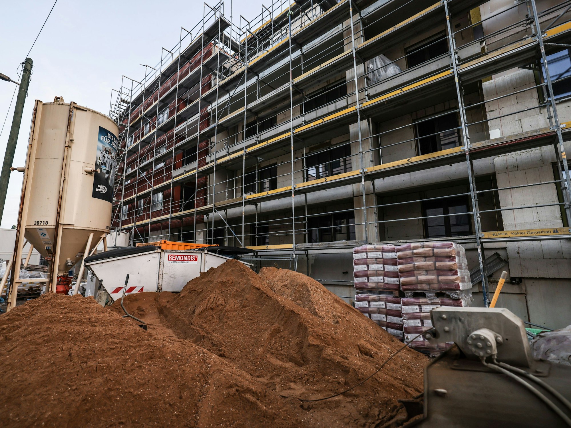 Ein Gerüst steht am Rohbau eines Wohnhauses.