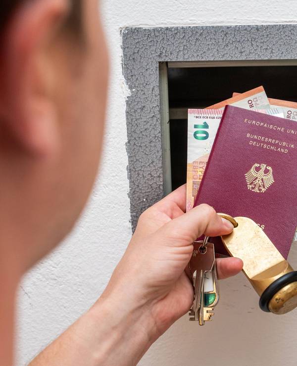 Urlauber schließt Wertsachen wie Bargeld und Reisepass in einen Safe im Hotelzimmer
