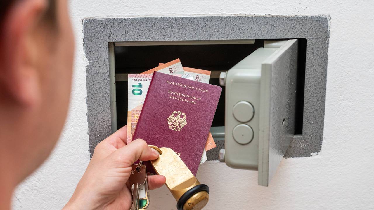 Urlauber schließt Wertsachen wie Bargeld und Reisepass in einen Safe im Hotelzimmer