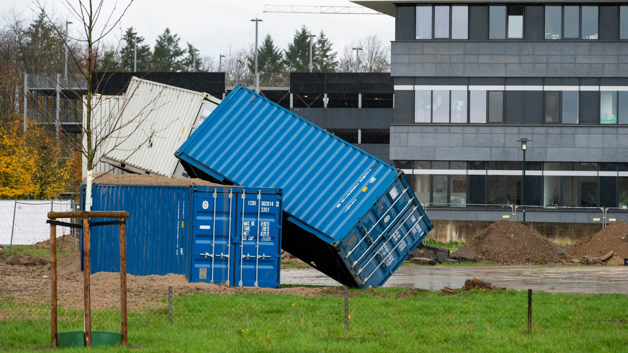 Zwei Container stehen halb auf einem dritten.