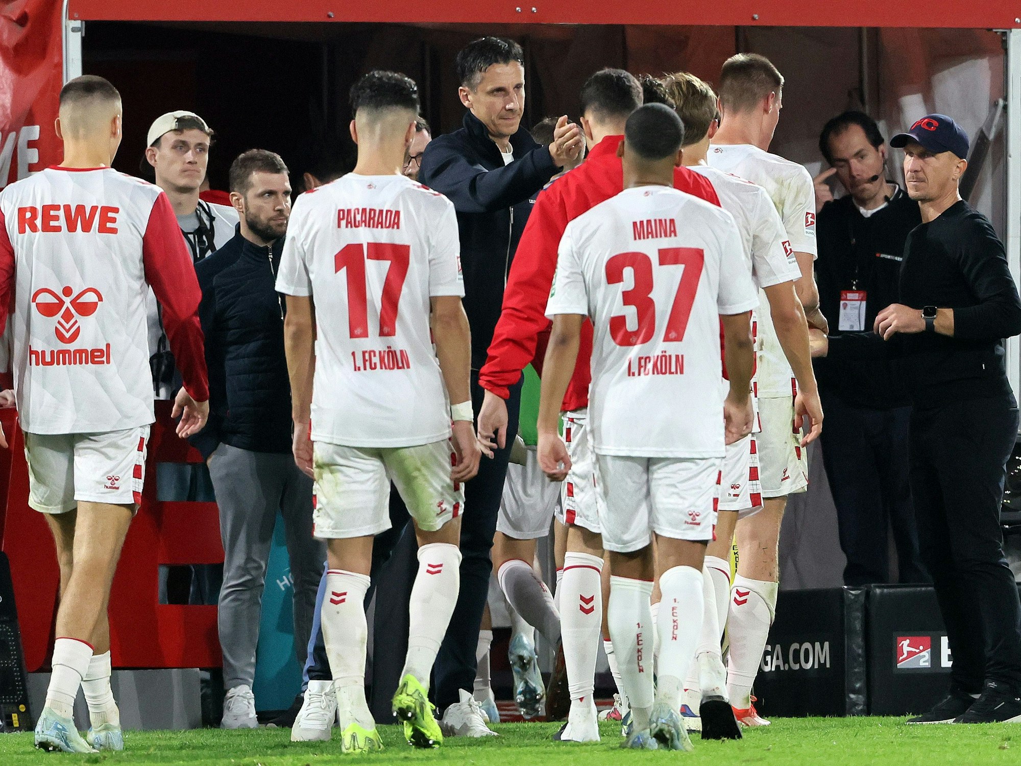 Christian Keller und Gerhard Struber klatschen mit den Spielern des 1. FC Köln ab.