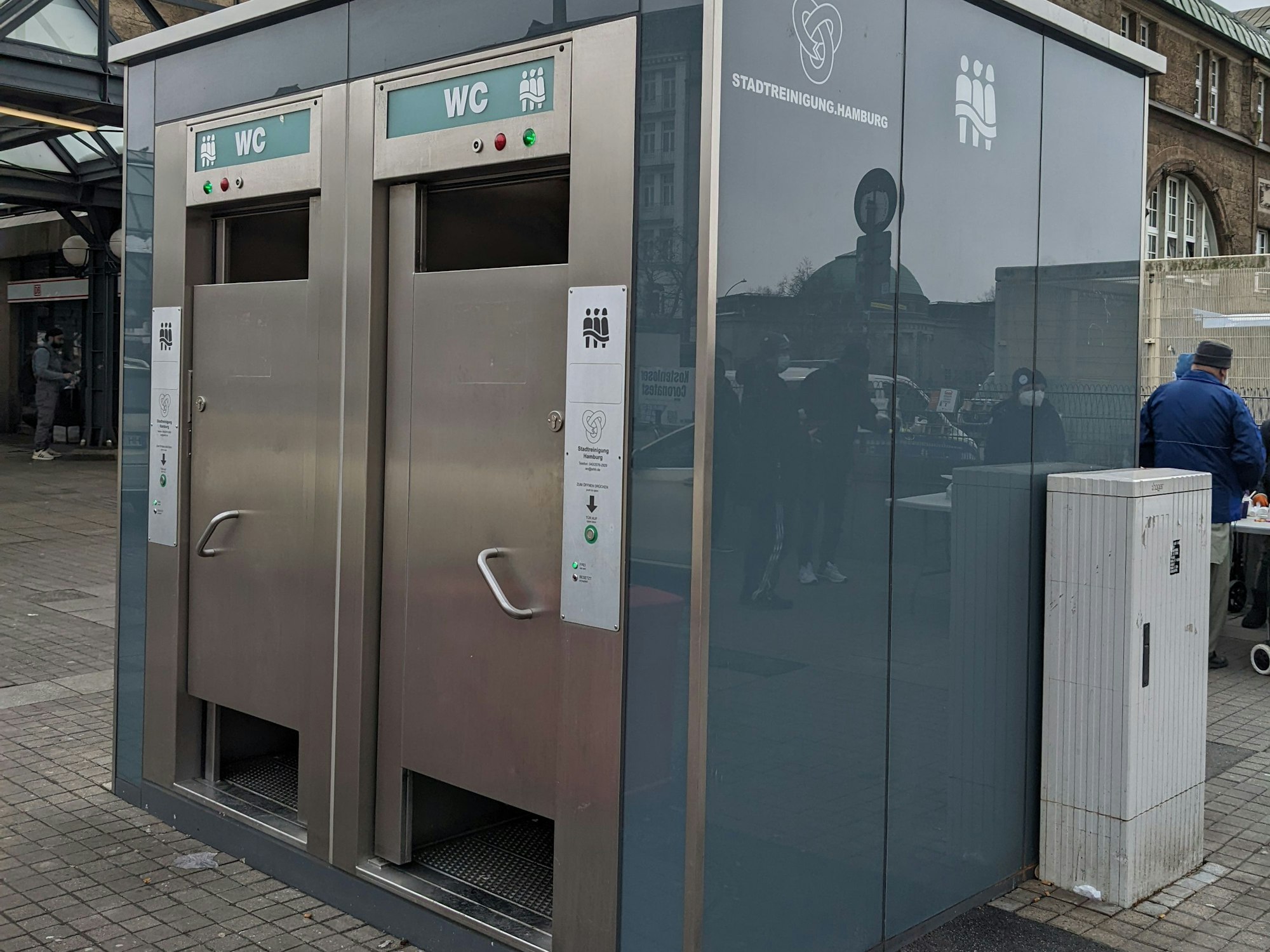 Das Foto zeigt eine öffentliche Toilette – eine Sitzen-Hocken-Stehen Anlage.