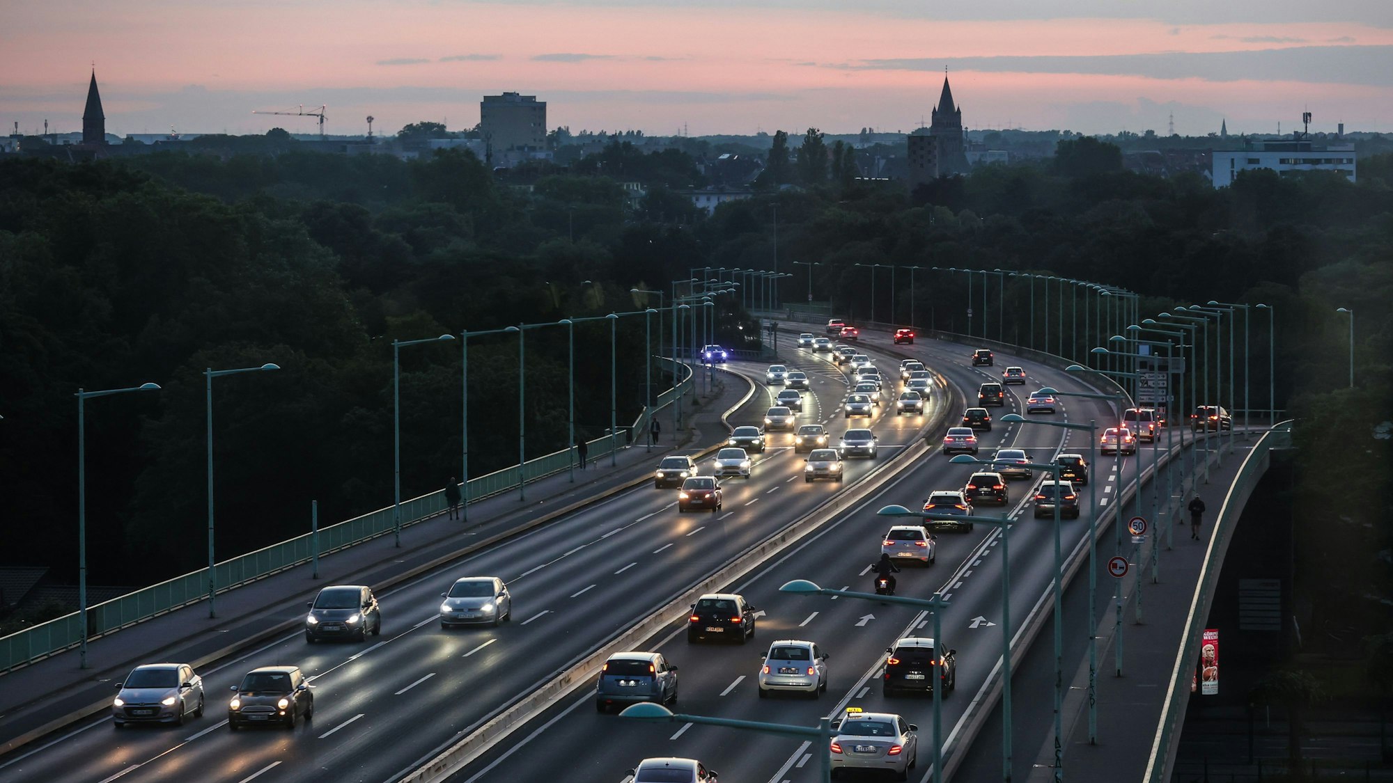 Autos fahren über die Zoobrücke bei Sonnenuntergang.