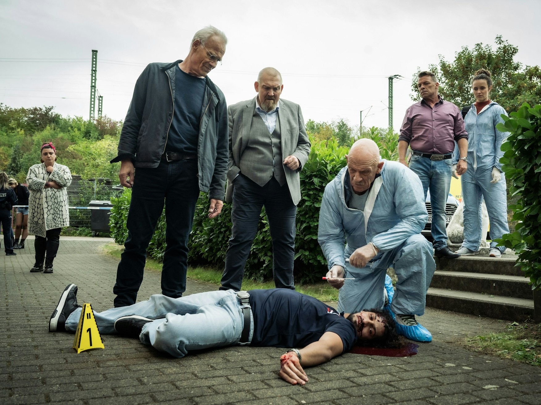 Max Ballauf (Klaus J. Behrendt), Freddy Schenk (Dietmar Bär) und der Rechtsmediziner Dr. Roth (Joe Bausch) begutachten Malik Zeman (Mehdi Salim).
