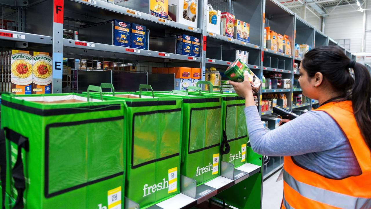 An employee of grocery delivery service Amazon Fresh scans ordered products in the company depot in Berlin, Germany, 18 July 2017. Amazon Fresh started in Berlin and Potsdam in early May, with a range of around 85,000 products. The company is now expanding its online supermarket to the northern city of Hamburg. Photo: Monika Skolimowska/dpa +++ dpa-Bildfunk +++