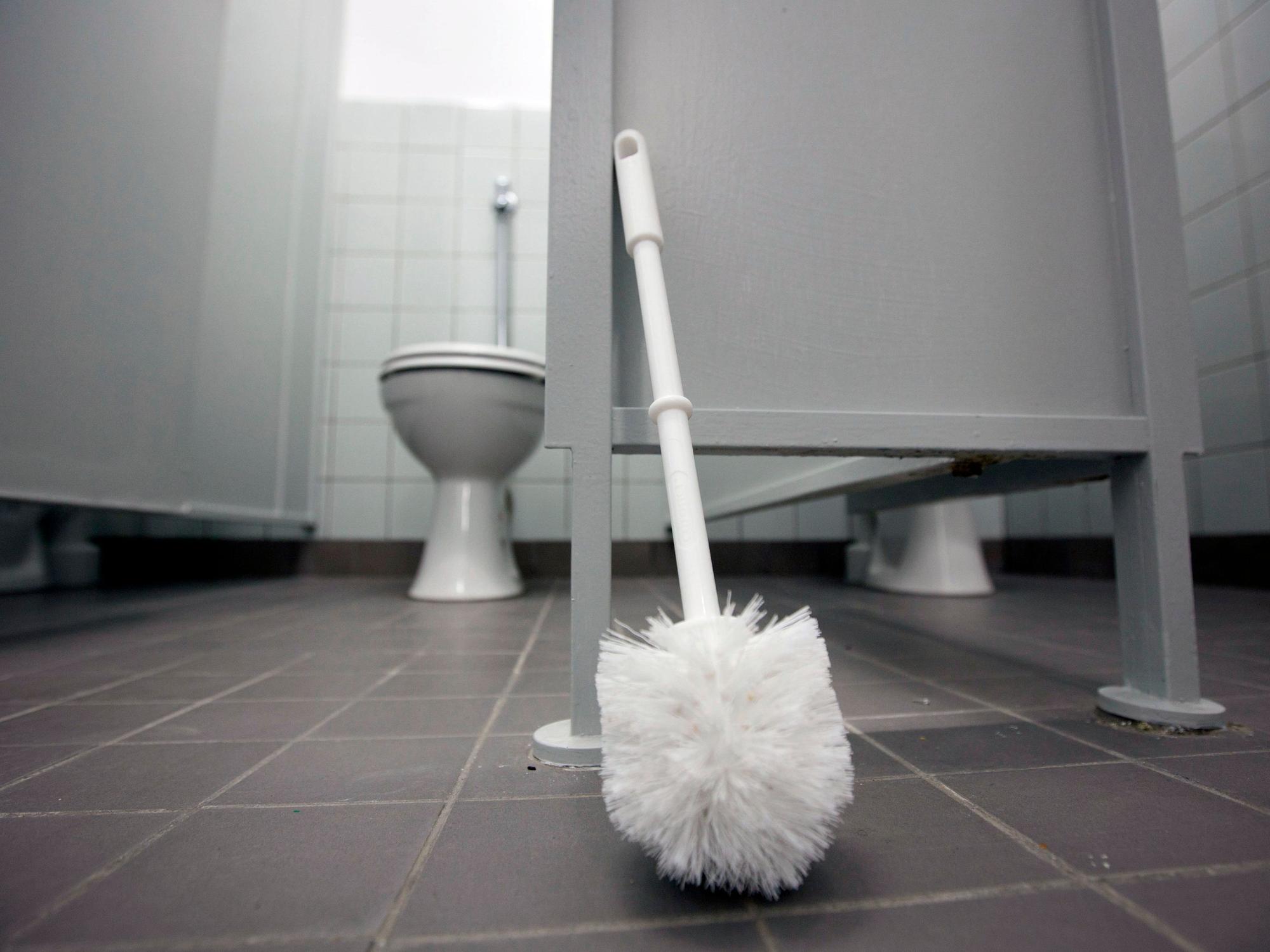 Eine Klobürste lehnt am 13.03.2012 an einer Tür im Toilettentrakt eine Schule in Groß-Bieberau.