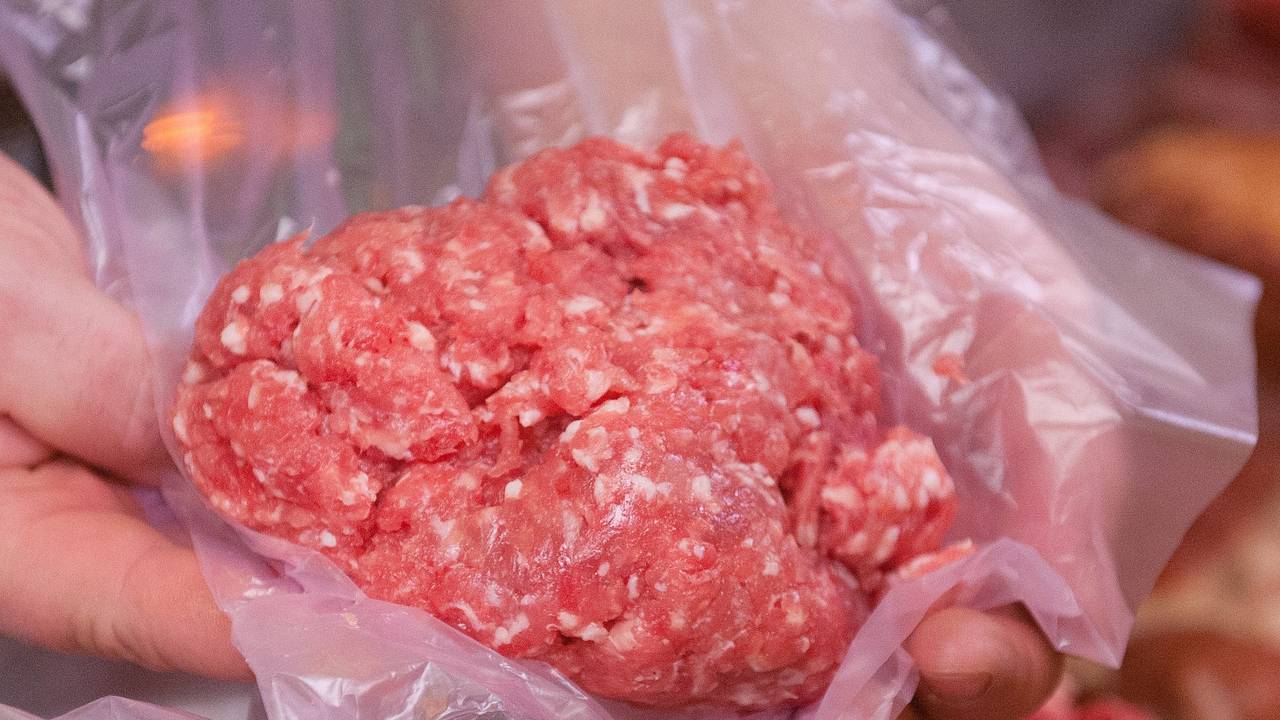 Ein Mitarbeiter eines Fleischerei-Fachgeschäfts hält eine Portion Mett in der Hand (Symbolfoto).