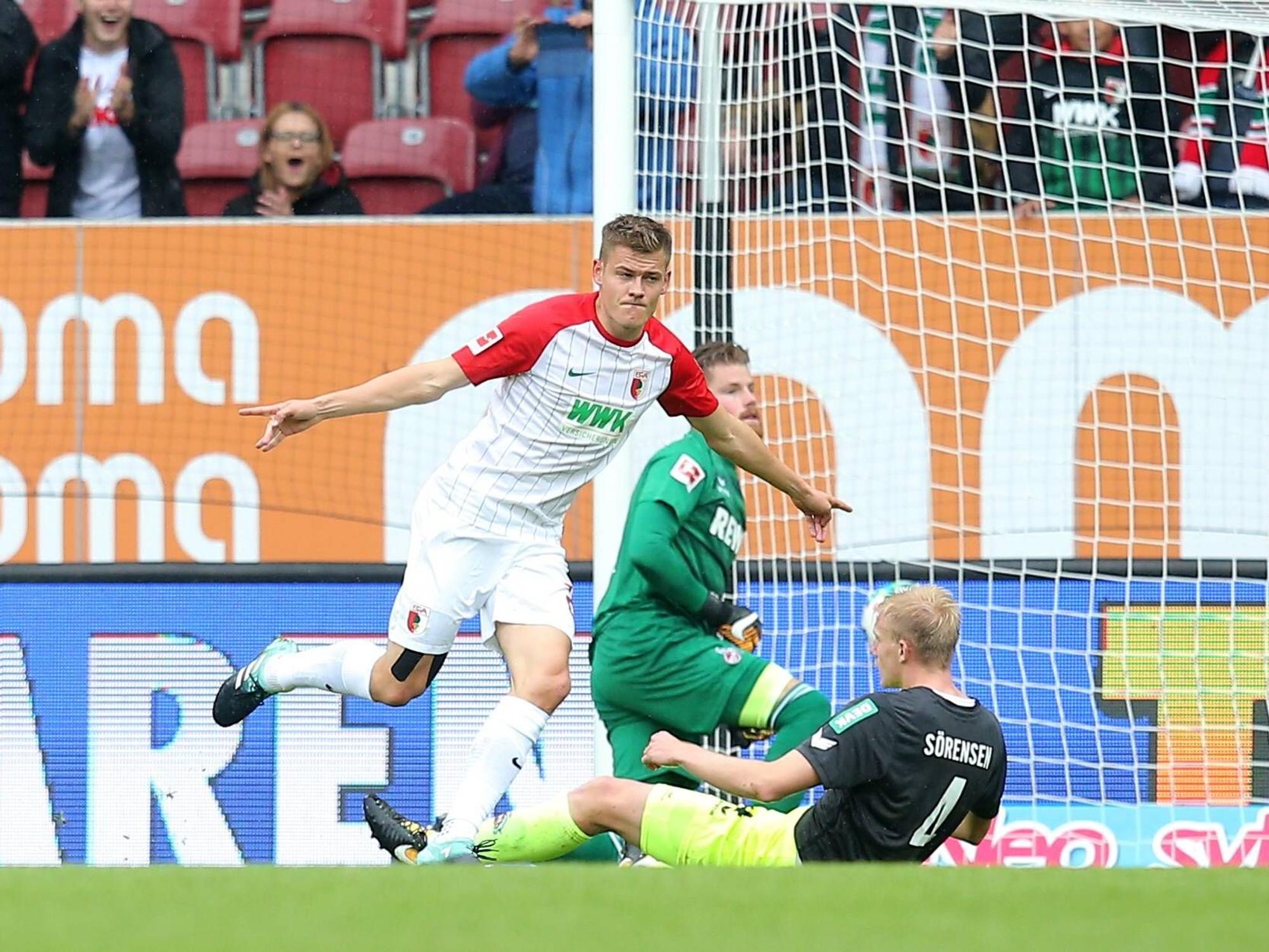 Alfred Finnbogason dreht nach seinem Tor gegen den 1. FC Köln jubelnd ab. Im Hintergrund ärgern sich die FC-Spieler Frederik Sörensen und Timo Horn.