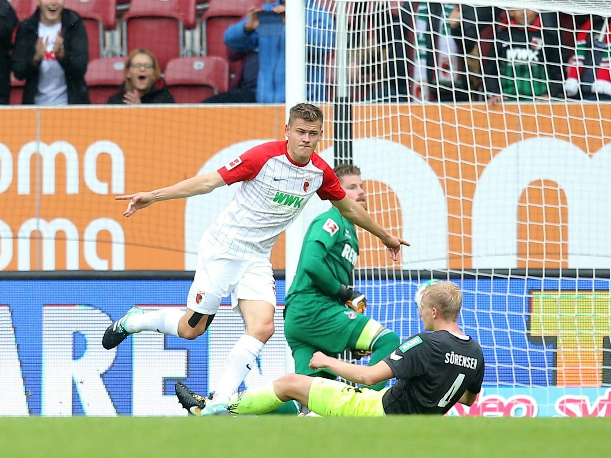 Alfred Finnbogason dreht nach seinem Tor gegen den 1. FC Köln jubelnd ab. Im Hintergrund ärgern sich die FC-Spieler Frederik Sörensen und Timo Horn.