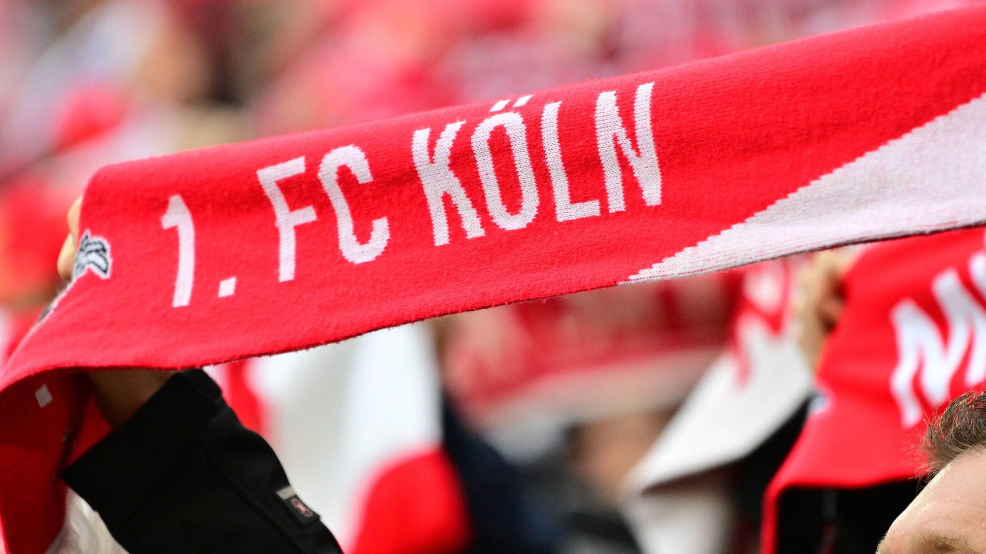 Ein Fan hält einen Schal mit der Aufschrift 1. FC Köln hoch.
