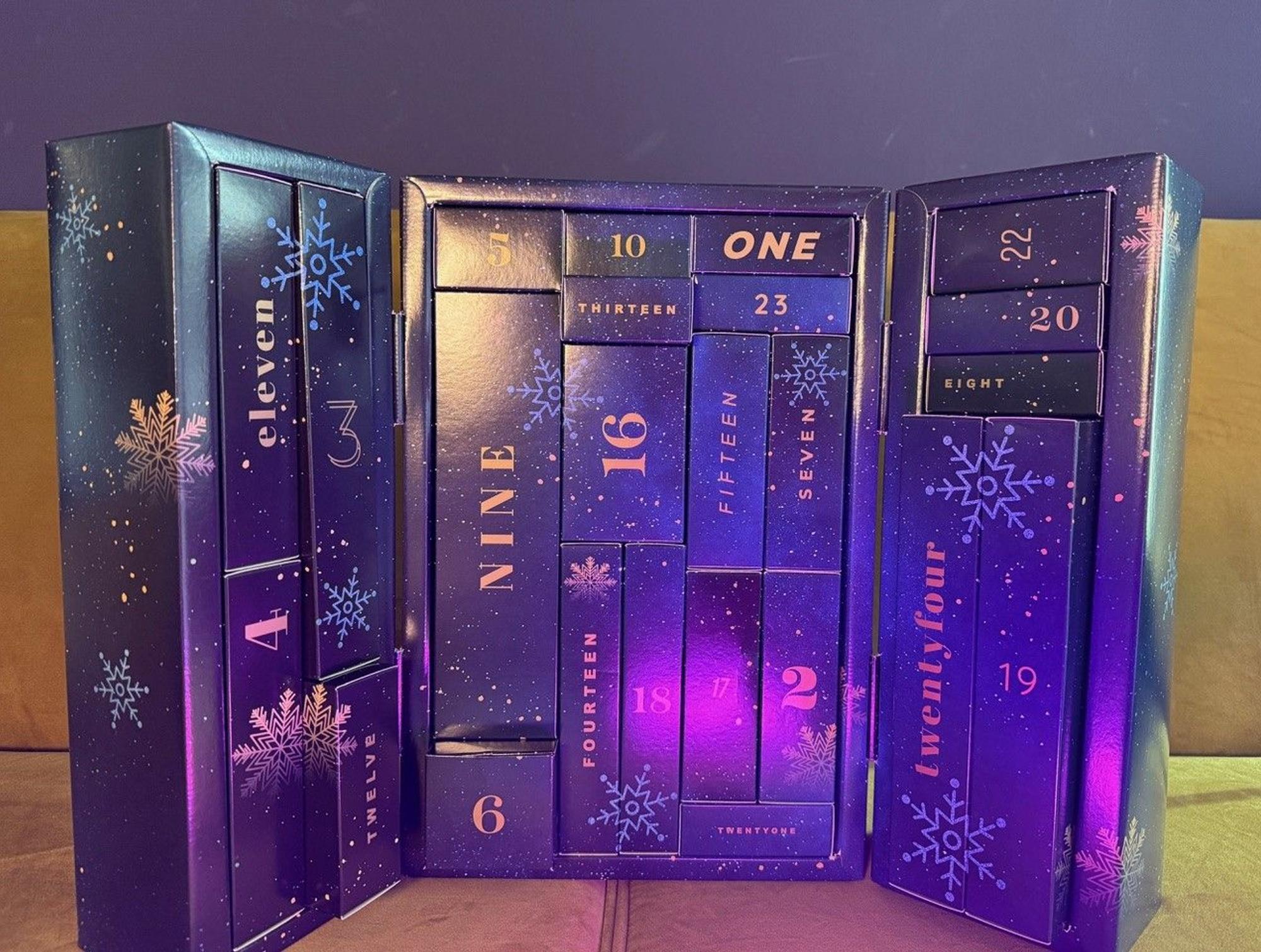 Eis Premium Adventskalender steht aufgeklappt auf einer Couch.