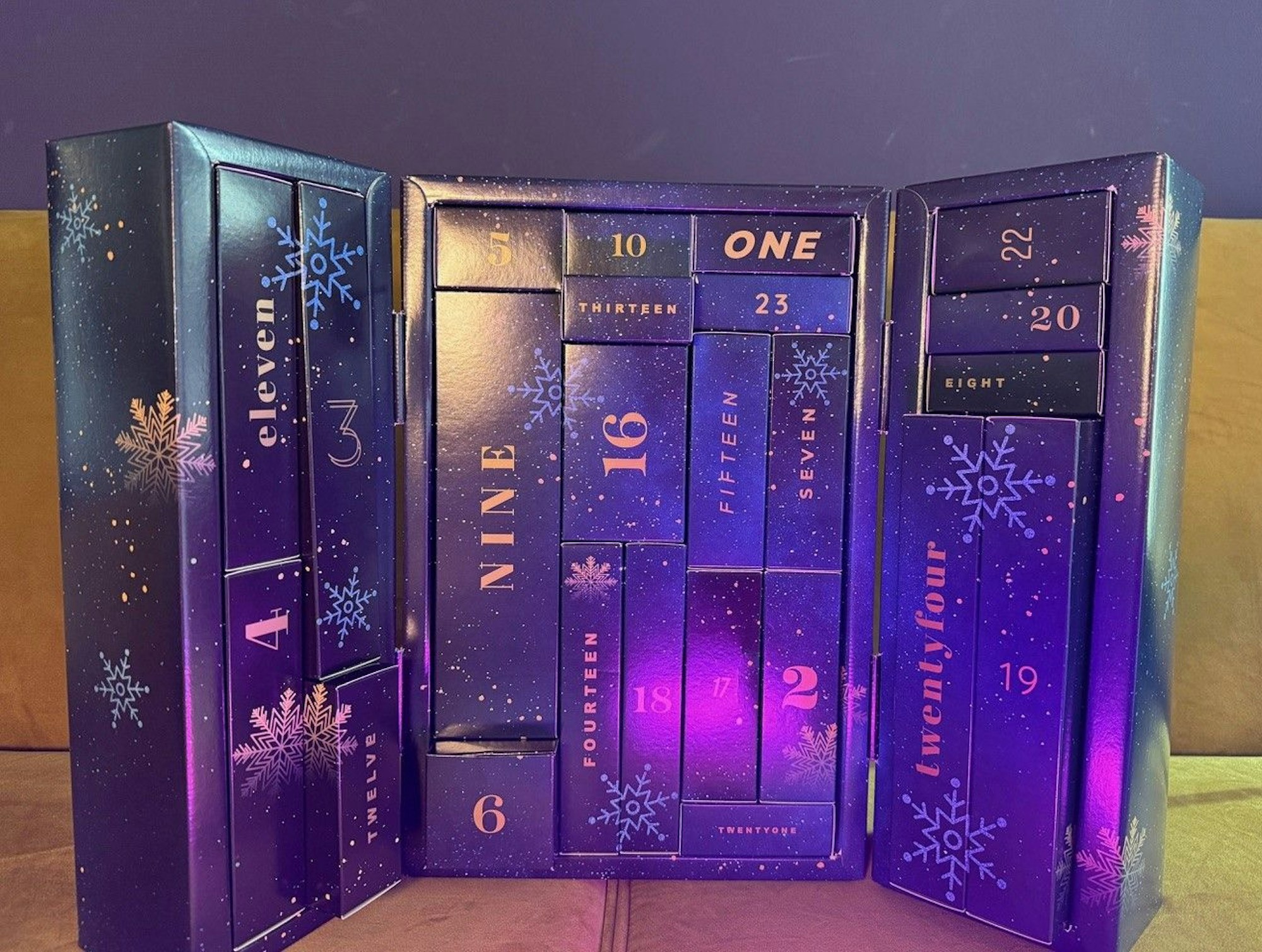 Eis Premium Adventskalender steht aufgeklappt auf einer Couch.