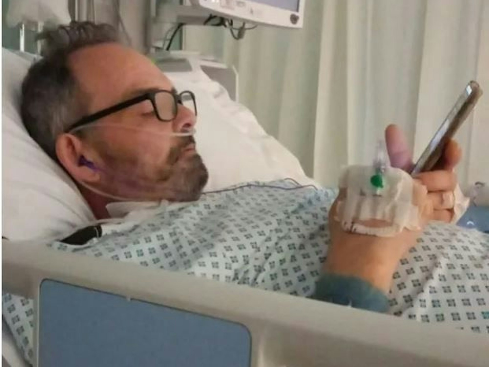 Simon English liegt in einem Krankenhausbett.