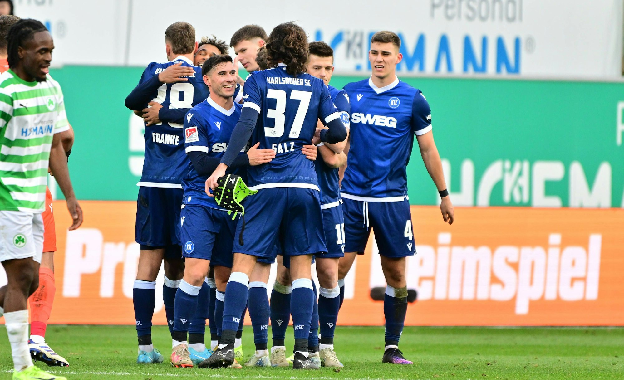 Dominik Salz feiert gemeinsam mit den KSC-Kollegen den Sieg im Zweitliga-Spiel in Fürth am 23. November 2024.