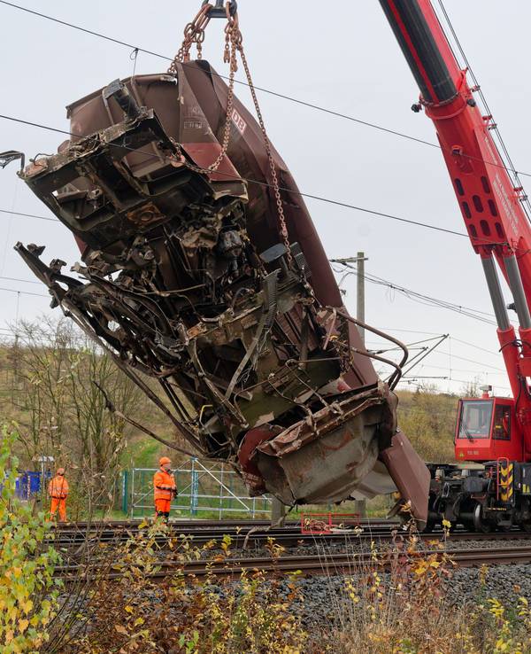 Ein zerstörter Wagen wird von einem Kran von den Gleisen gehoben.