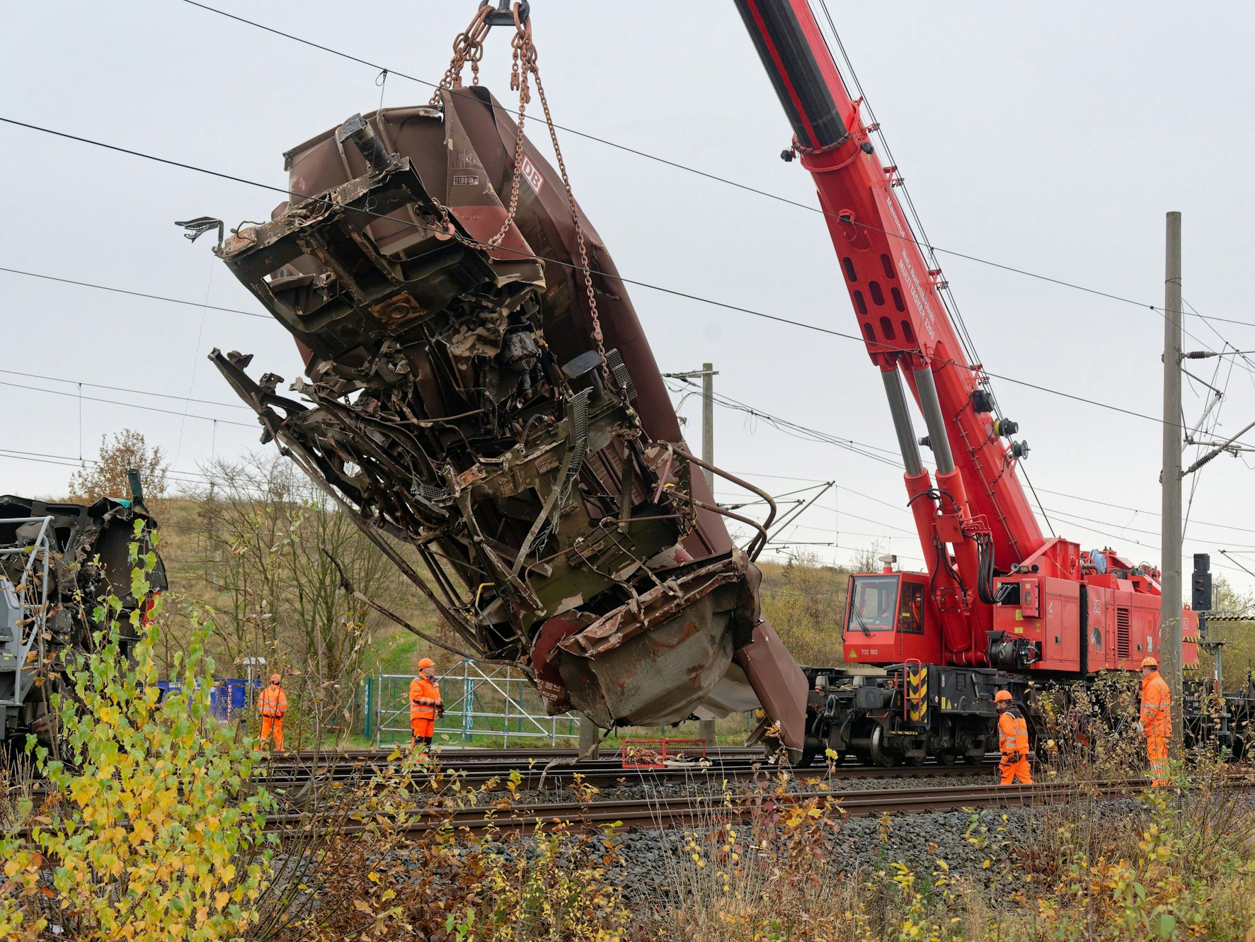 Ein zerstörter Wagen wird von einem Kran von den Gleisen gehoben.