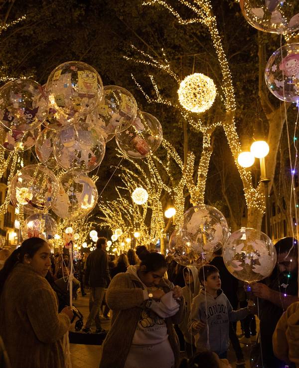 Menschen beobachten am 23. November 2024 die Weihnachtsbeleuchtung in der Innenstadt von Palma auf Mallorca. Bis Ende Januar sind die Hauptstraßen der Stadt mit Lichtern geschmückt.