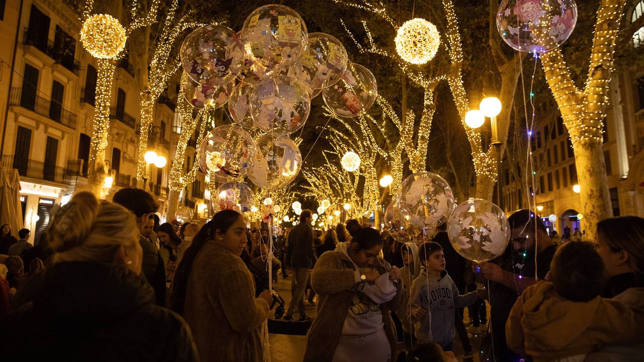 Menschen beobachten am 23. November 2024 die Weihnachtsbeleuchtung in der Innenstadt von Palma auf Mallorca. Bis Ende Januar sind die Hauptstraßen der Stadt mit Lichtern geschmückt.