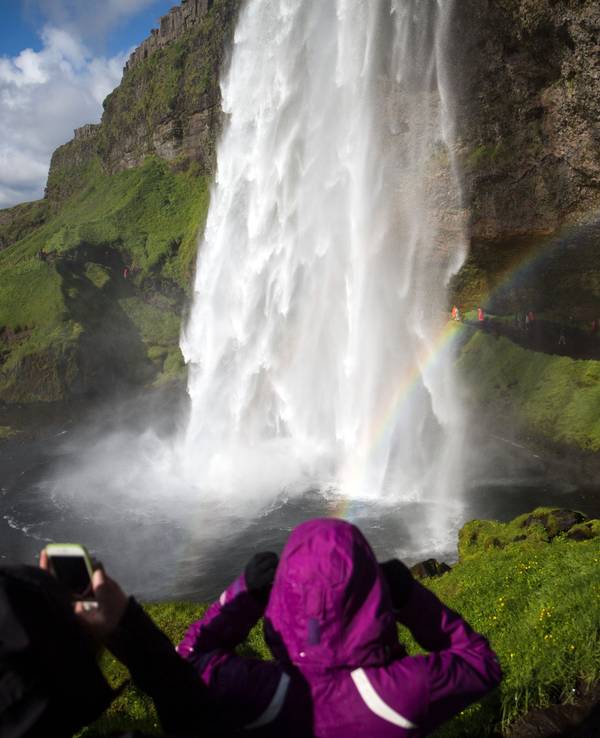 Touristen und Touristinnen besichtigen den Wasserfall „Seljalandsfoss“ auf Island. Das Symbolfoto entstand 2018.