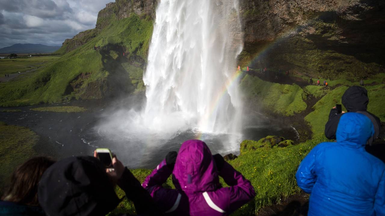 Touristen und Touristinnen besichtigen den Wasserfall „Seljalandsfoss“ auf Island. Das Symbolfoto entstand 2018.