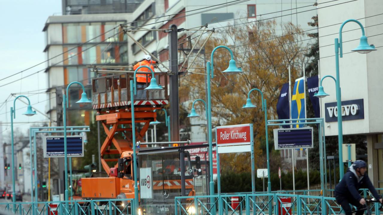 Ein Mann steht auf einer Hubplattform und arbeitet an den Oberleitungen der Bahn.