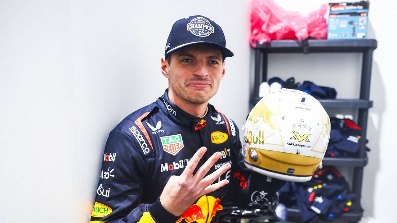 Max Verstappen zeigt vier Finger in die Kamera und hält seinen Helm.
