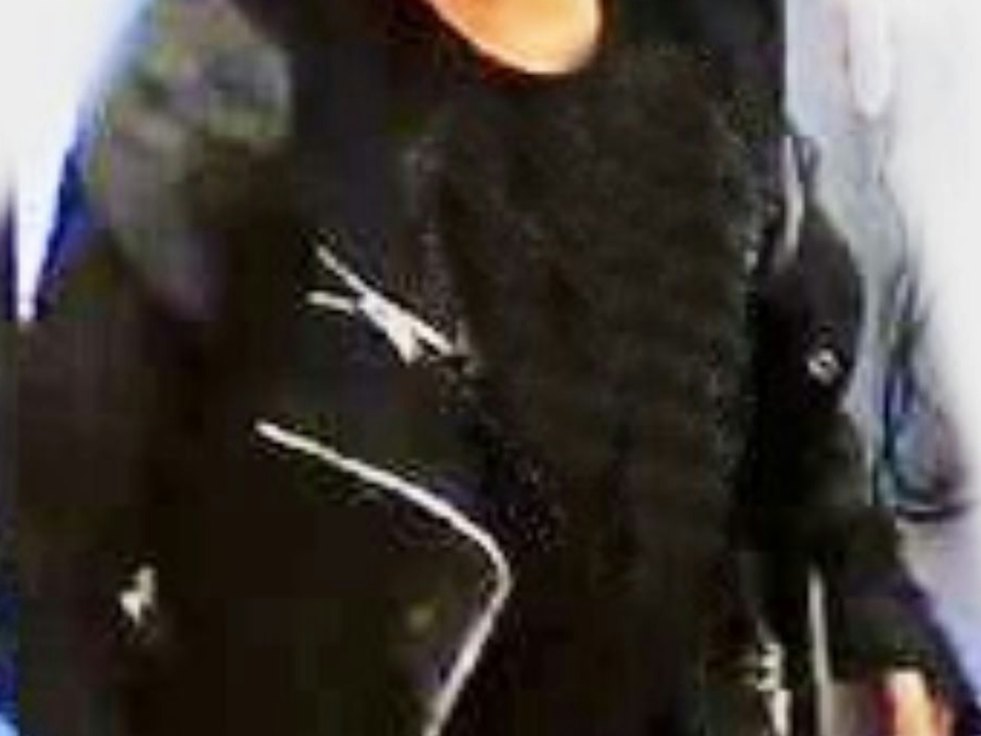 Eine Person trägt eine Jacke mit Reißverschlüssen.