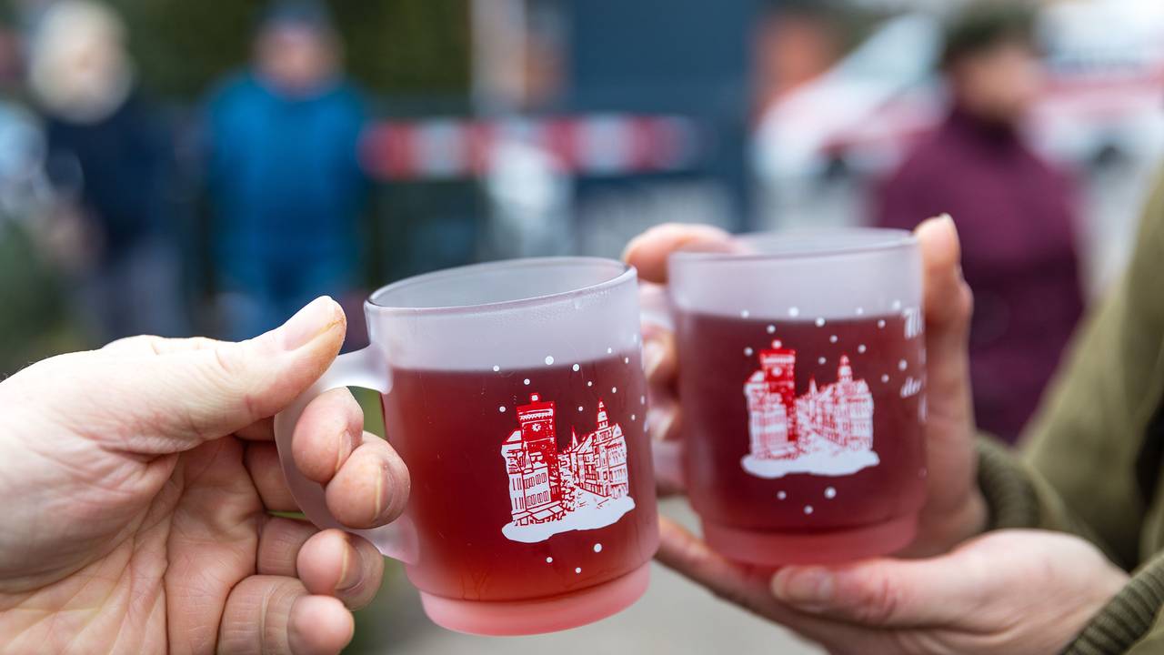 Menschen halten beim traditionellen Weihnachtsbaumweitwurf bei der Ströbitzer Feuerwehr Tassen mit Glühwein in den Händen und wärmen sich daran. Am Wettbewerb im Cottbuser Ortsteil Ströbitz, bei dem gewinnt, wer einen Weihnachtsbaum am weitesten werfen kann, nahmen mehr als 80 Besucher teil. Vorher konnten sie sich, gemeinsam mit anderen Besuchern beim Essen stärken. Der Erlös der Veranstaltung wird einer sozialen Einrichtung in der Stadt Cottbus gespendet. (zu dpa: «Viele Glühweine verstoßen gegen Kennzeichnungsvorgaben») +++ dpa-Bildfunk +++