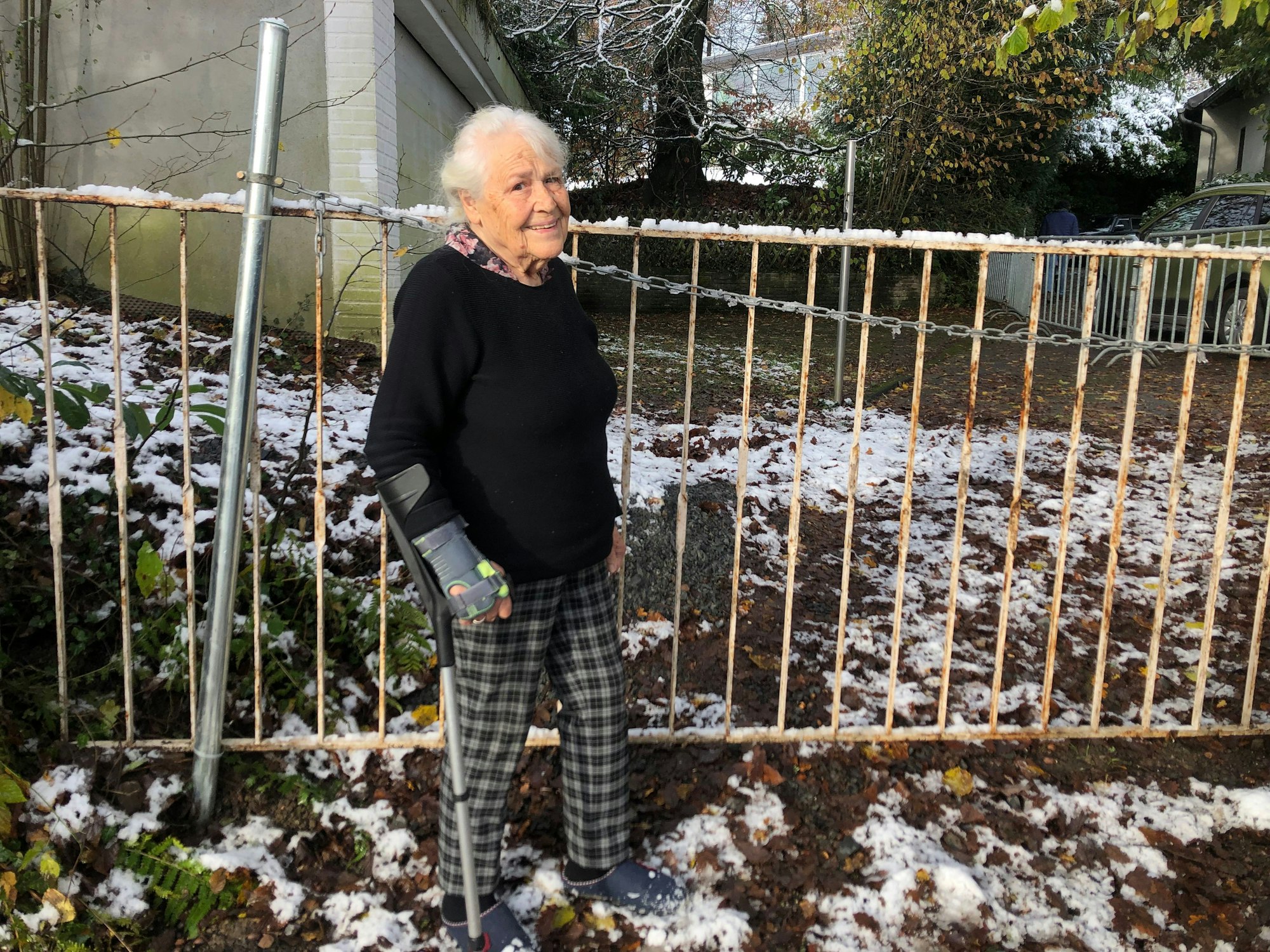 Irmintraut Fuchs an dem Zaun, den ihr Nachbar aufgebaut hat und der den Zugang zu ihrem Grundstück versperrt.