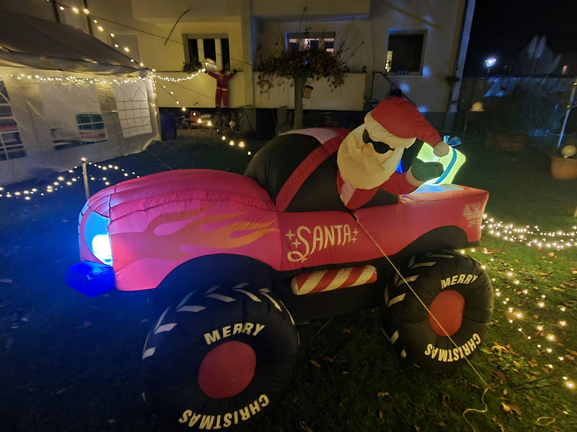 Ein aufblasbarer Weihnachtsmann mit Geländewagen steht im Garten der Familie Trimborn.