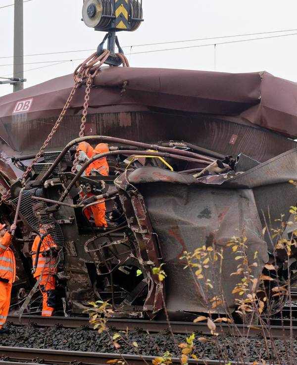 Mehrere Personen bereiten die Bergung eines völlig zerstörten Waggons vor.