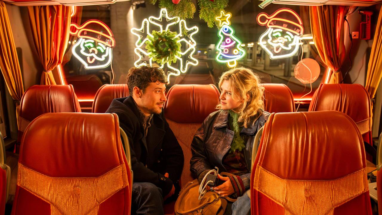 Zwei Menschen sitzen in einem Bus und schauen sich an
