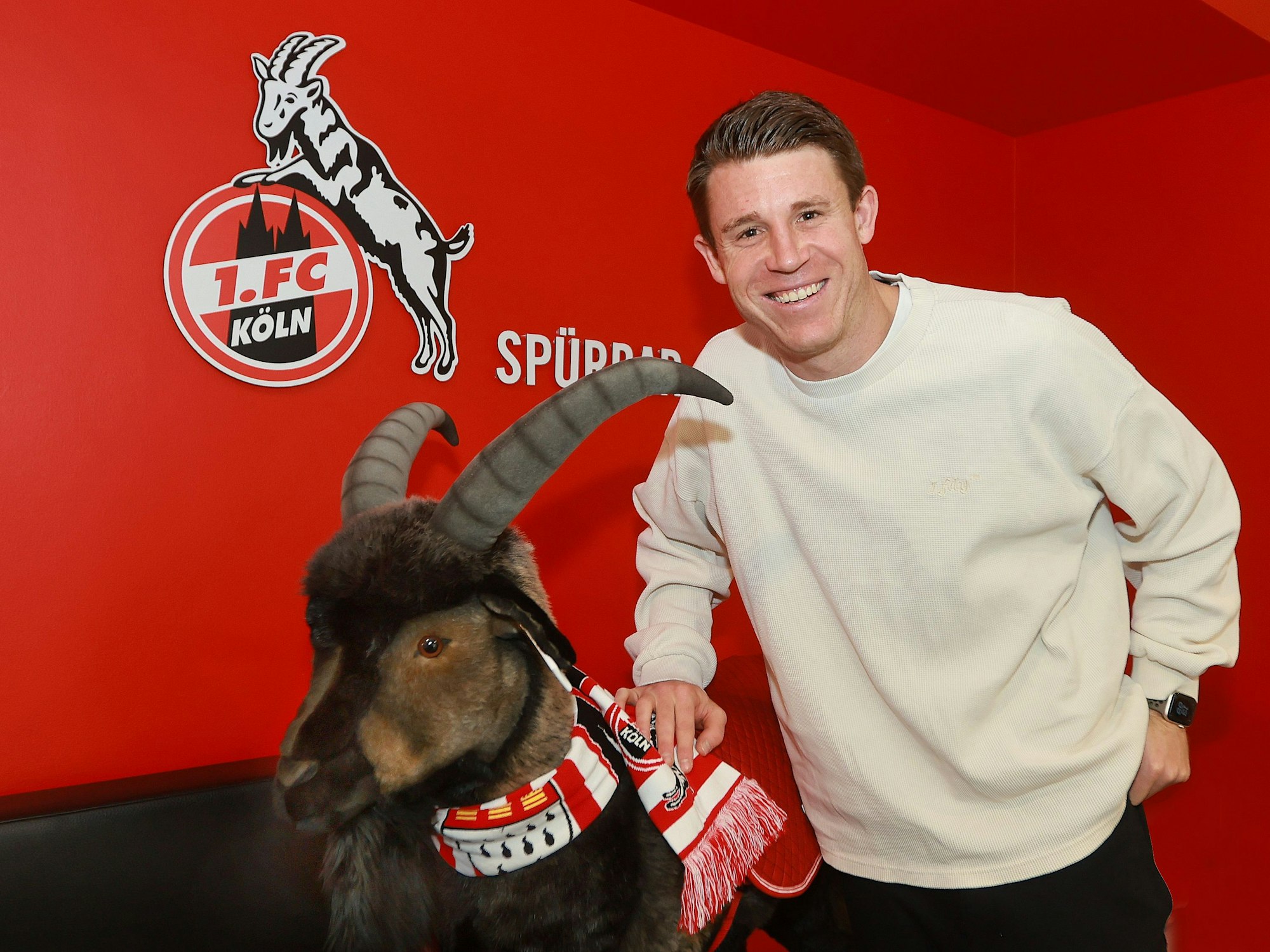 Verteidiger Dominique Heintz (1. FC Köln) im Geißbockheim mit Maskottchen Hennes aus Stoff.
