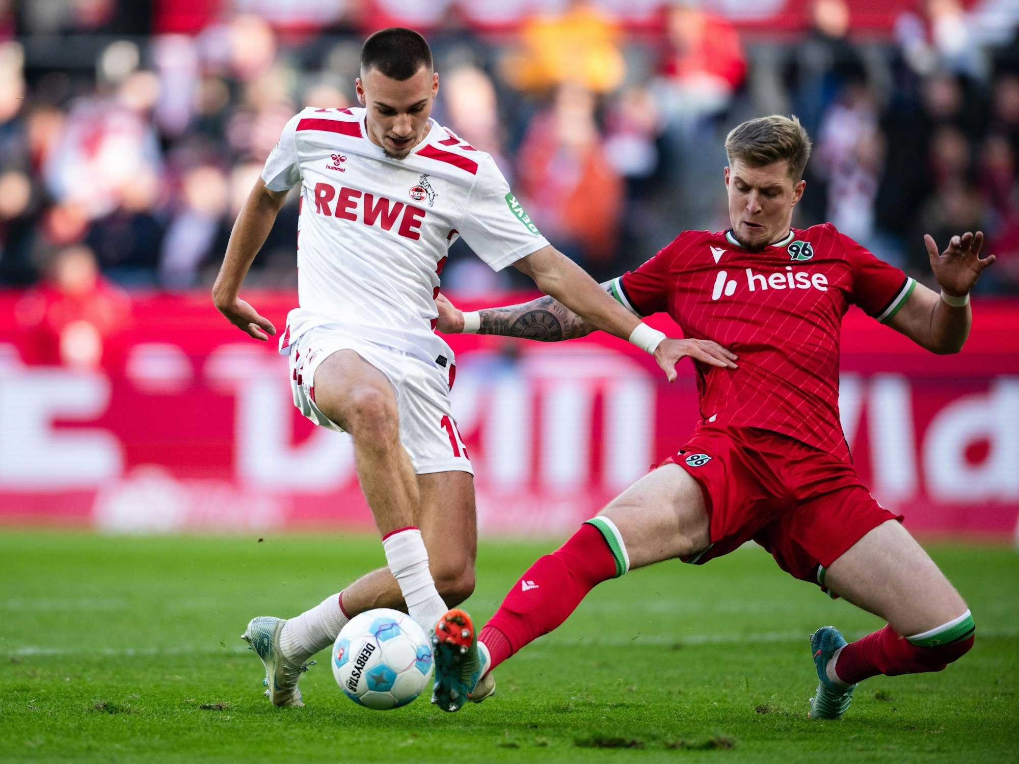 Kölns Tim Lemperle (l) und Hannovers Josh Knight kämpfen um den Ball.