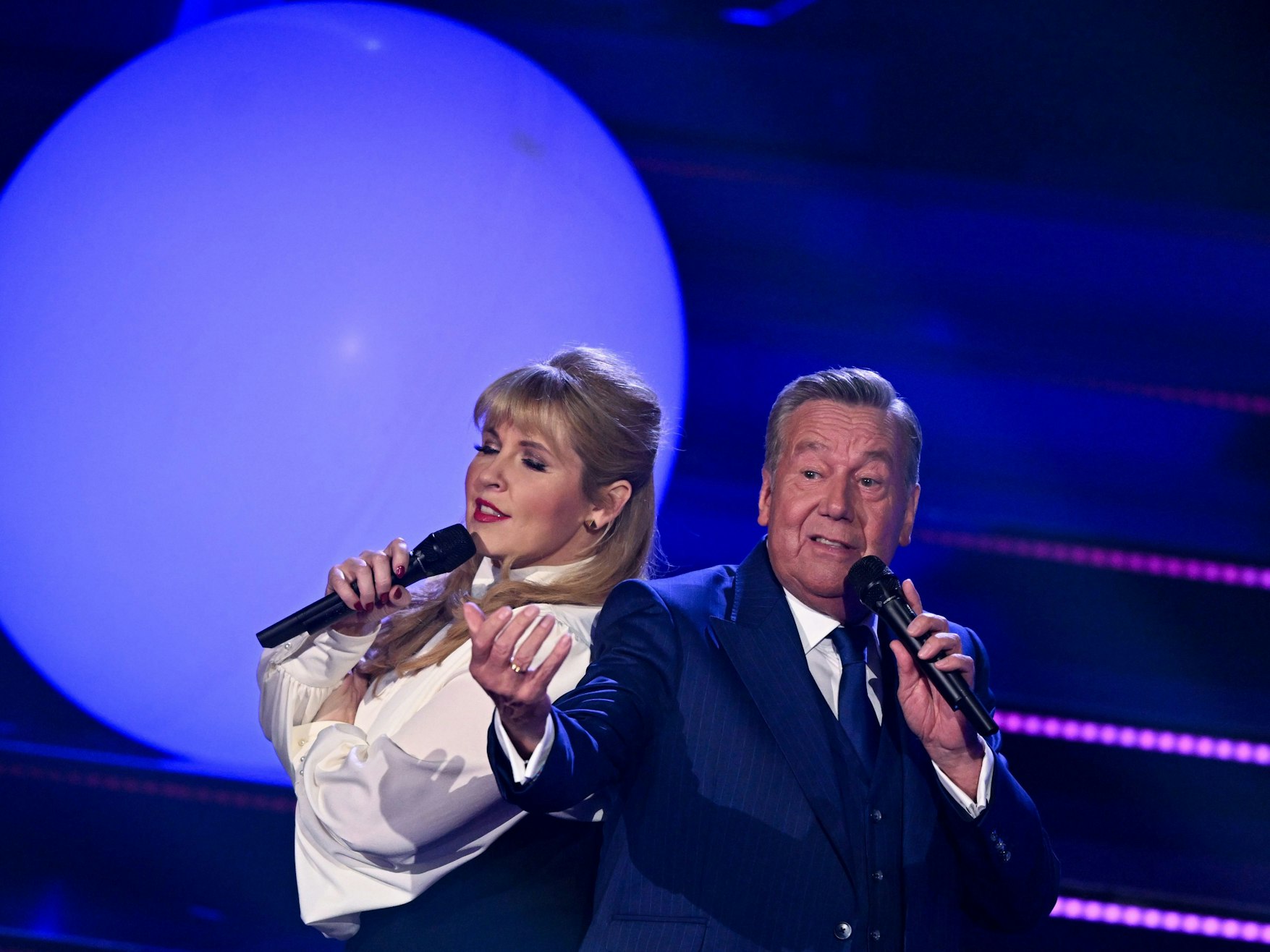 Sängerin Maite Kelly und der deutsche Schlagersänger Roland Kaiser stehen gemeinsam auf der Bühne.