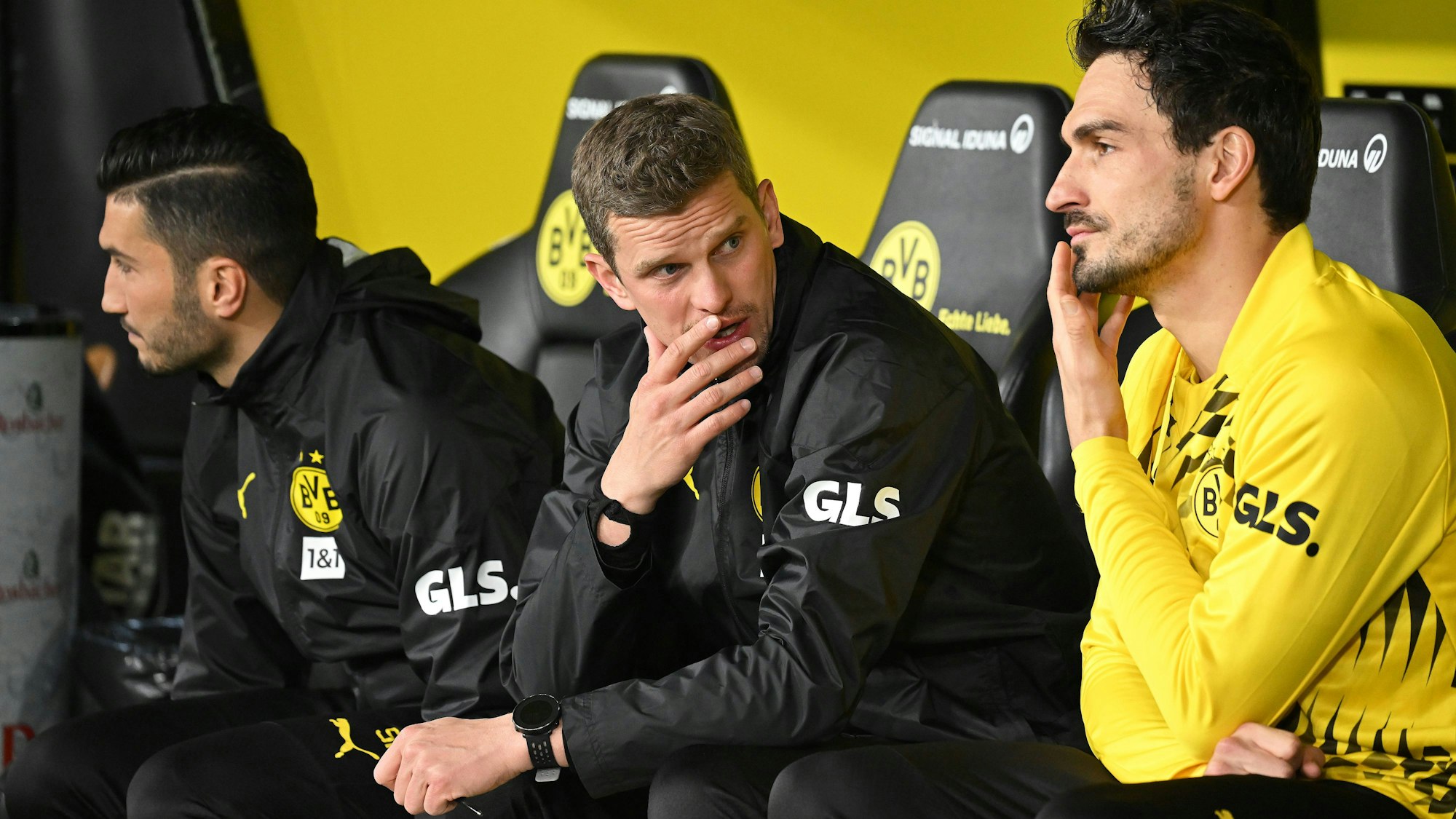 Sven Bender auf der Bank im Gespräch mit Mats Hummels. Im Hintergrund ist Nuri Sahin zu sehen.