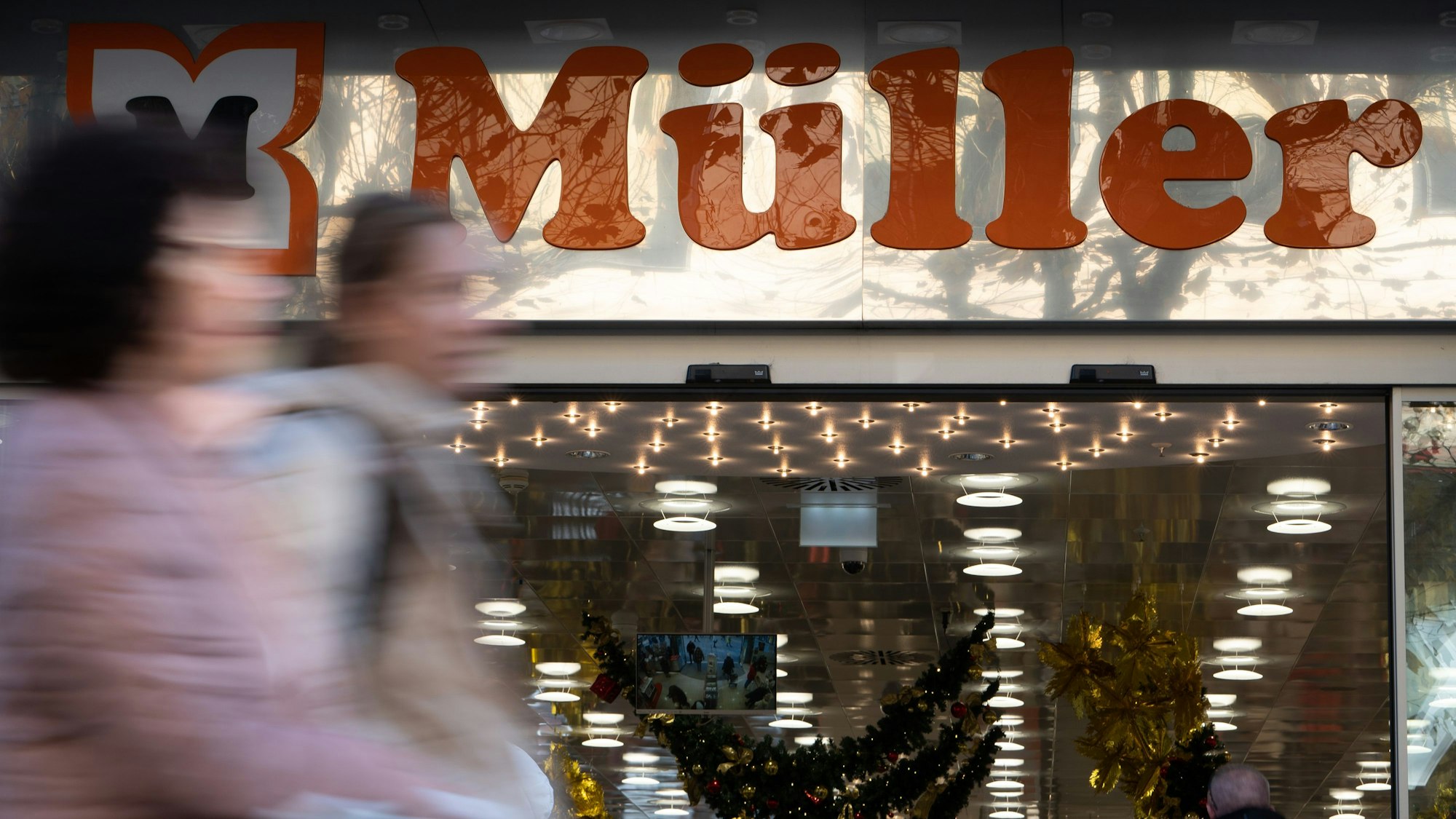 Menschen gehen an einem Geschäft der Drogeriemarktkette Müller in der Königstraße vorbei.
