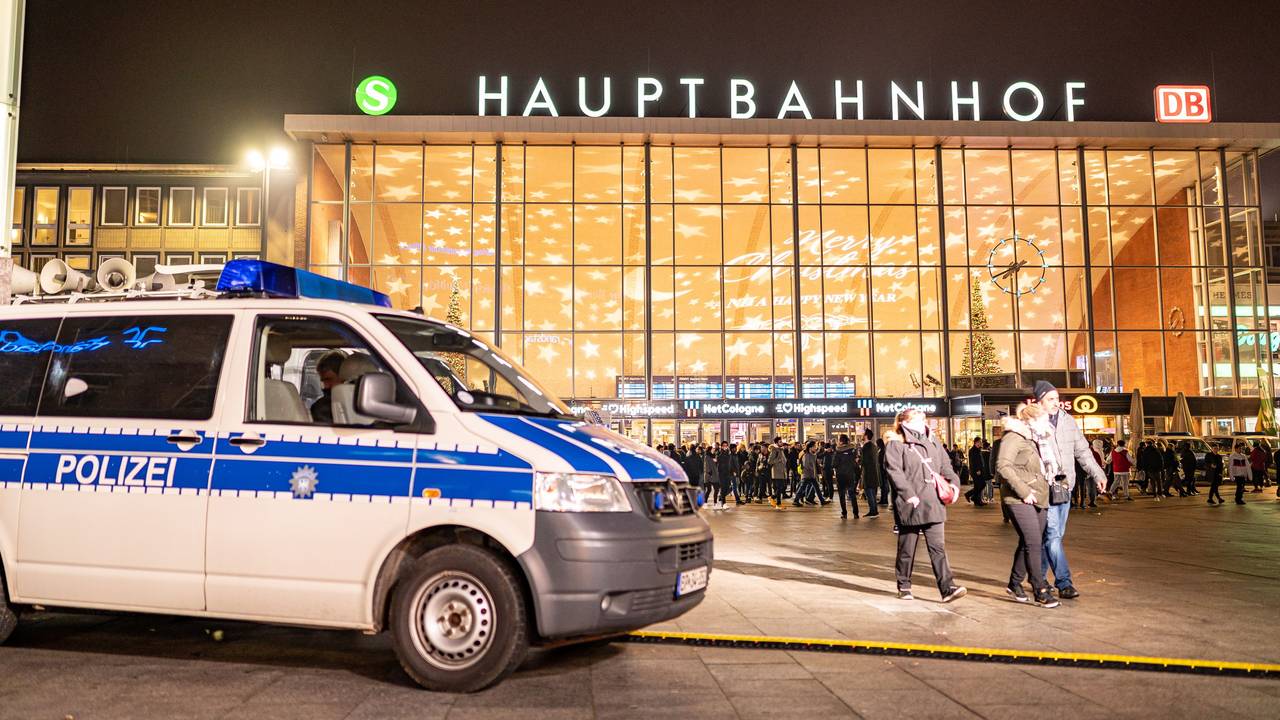 Streifenwagen der Polizei steht vor dem Kölner Hauptbahnhof, im Hintergrund sind einige Menschen zu Fuß unterwegs.