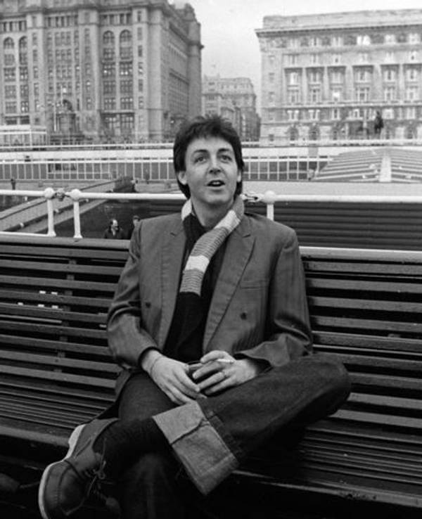 Paul McCartney sitzt auf einer Bank auf einem Schiff.