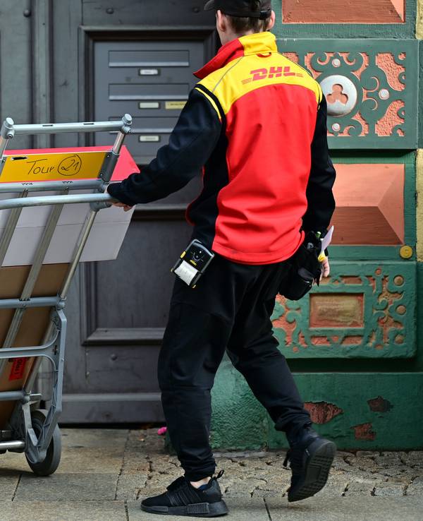 Ein DHL Mitarbeiter liefert Sendungen aus in der Erfurter Innenstadt.
