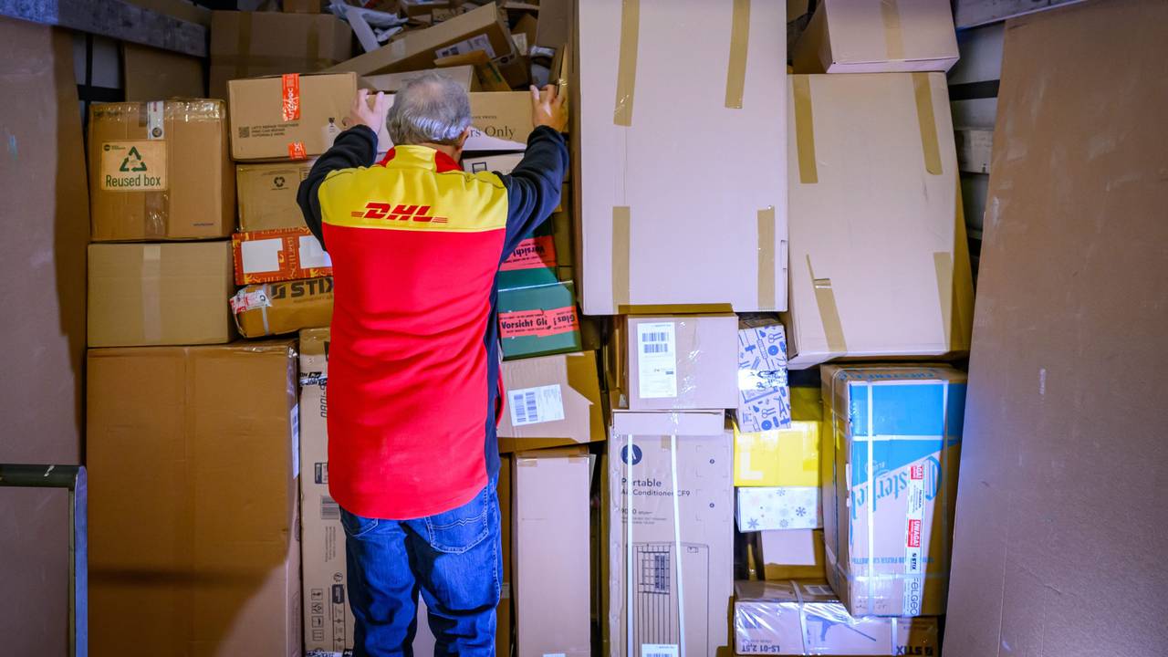 Ein Mitarbeiter bestückt im DHL-Paketzentrum den Laderaum eines Lkw mit Päckchen und Paketen.
