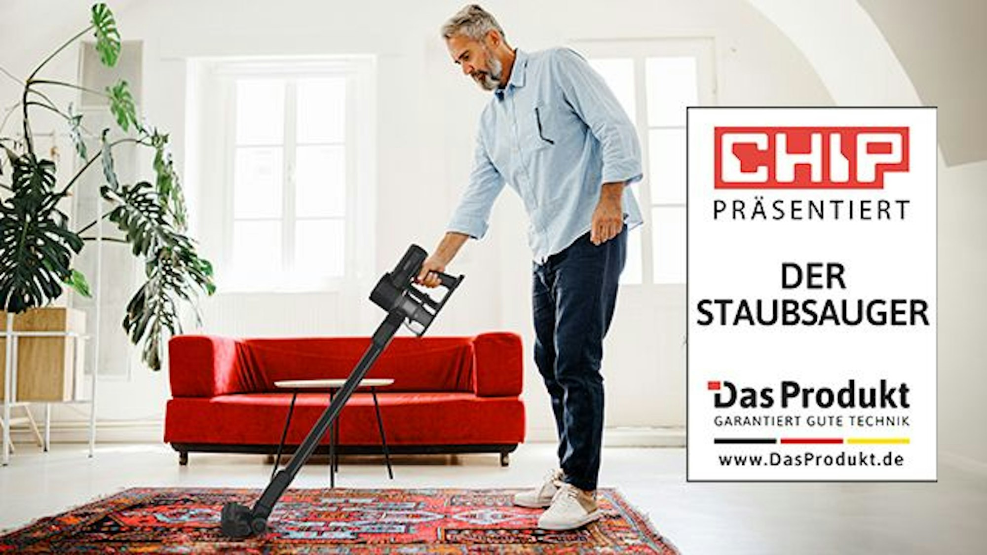 "Der Staubsauger" wird von einer männlichen Person im Wohnzimmer benutzt