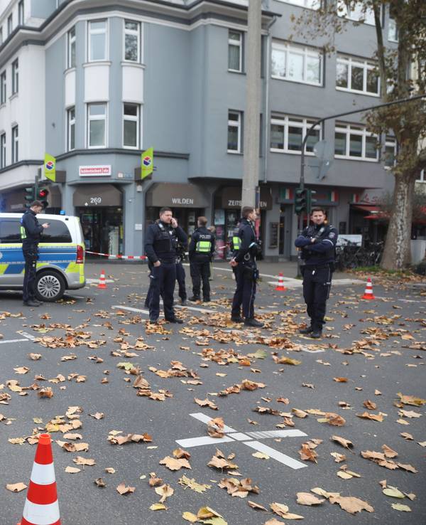 Mehrere Polizisten stehen nach einem Unfall in Köln auf einer Kreuzung.