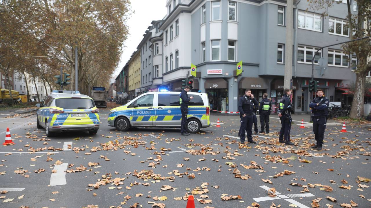 Mehrere Polizisten stehen nach einem Unfall in Köln auf einer Kreuzung.