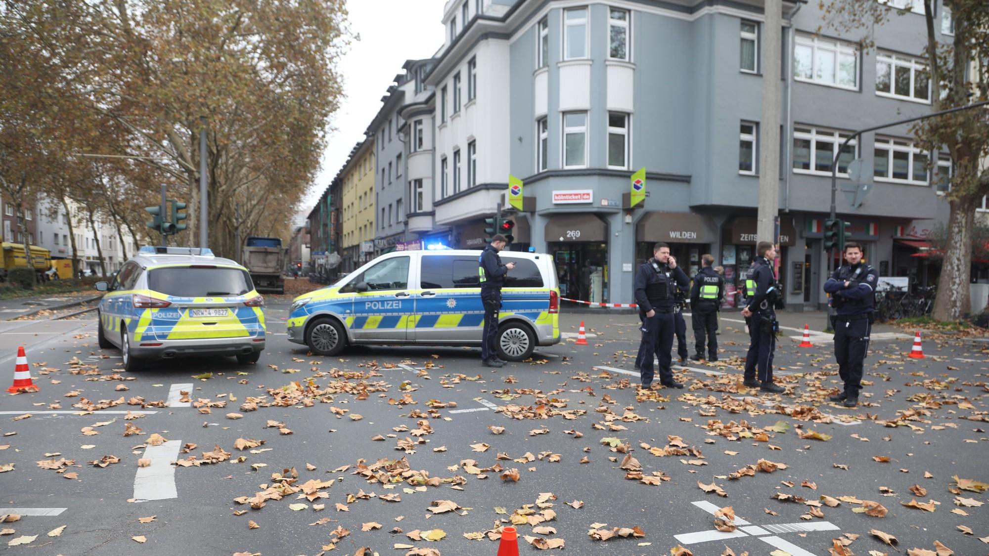 Mehrere Polizisten stehen nach einem Unfall in Köln auf einer Kreuzung.