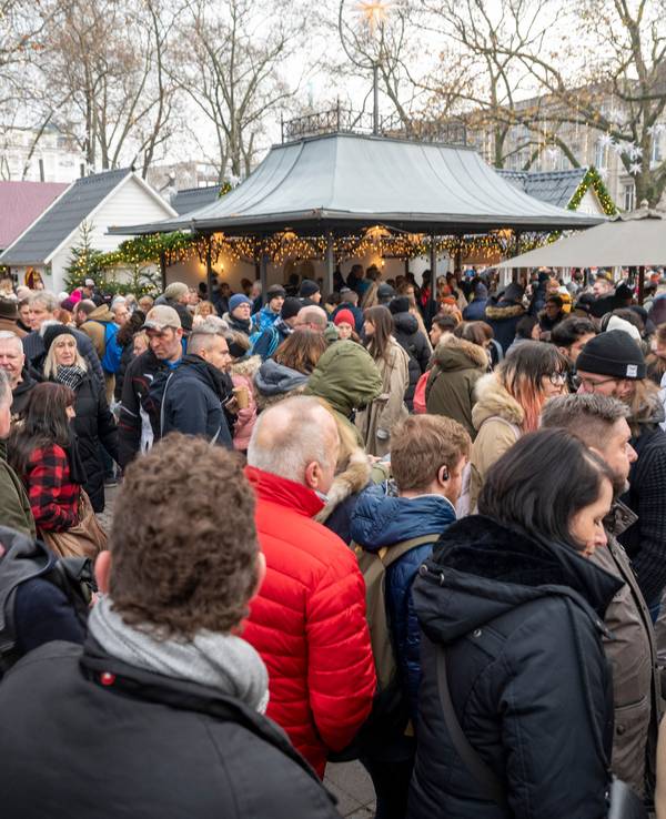 Viele Menschen stehen dicht an dicht auf dem Weihnachtsmarkt am Kölner Neumarkt.